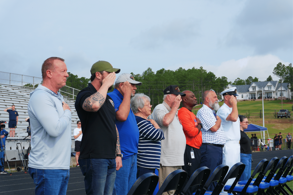 Leadership and families saluting the colors.