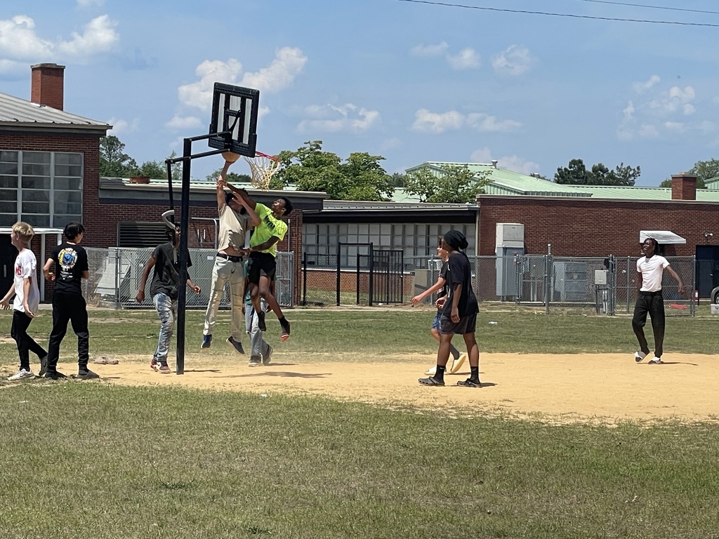 Boys playing basketball outside.