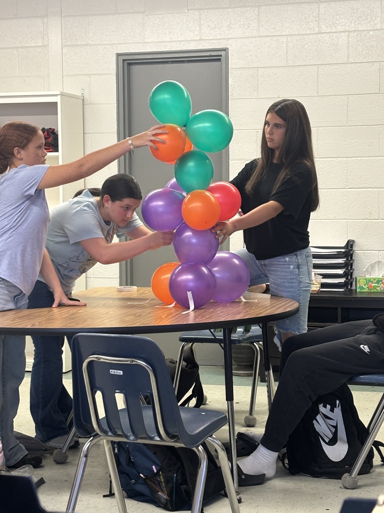 Girls building largest balloon tower.