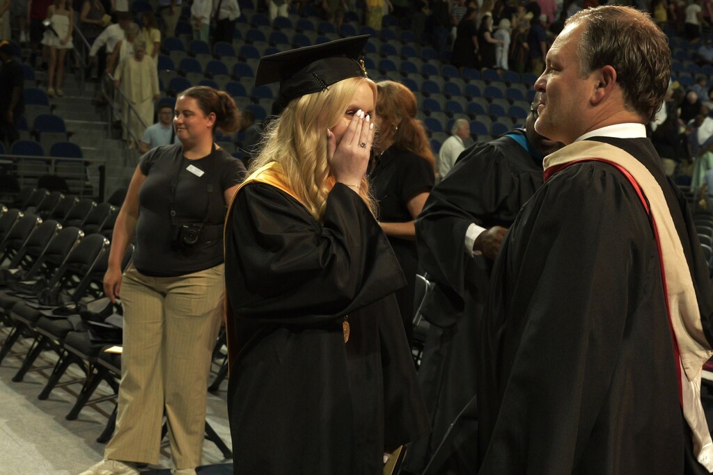 NAHS female student wipes away a tear as she hugs her dad, CFO Tray Traxler. 