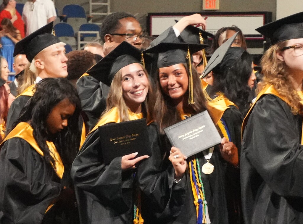 Two NAHS female students posing with their diplomas. 