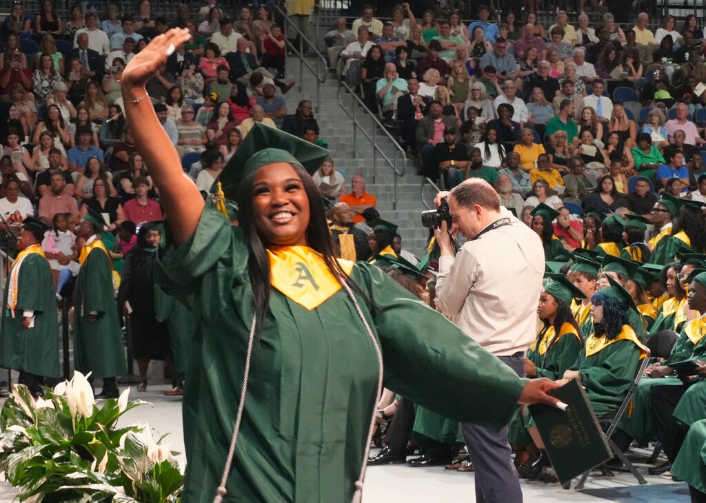An Aiken High graduate waves to the audience.