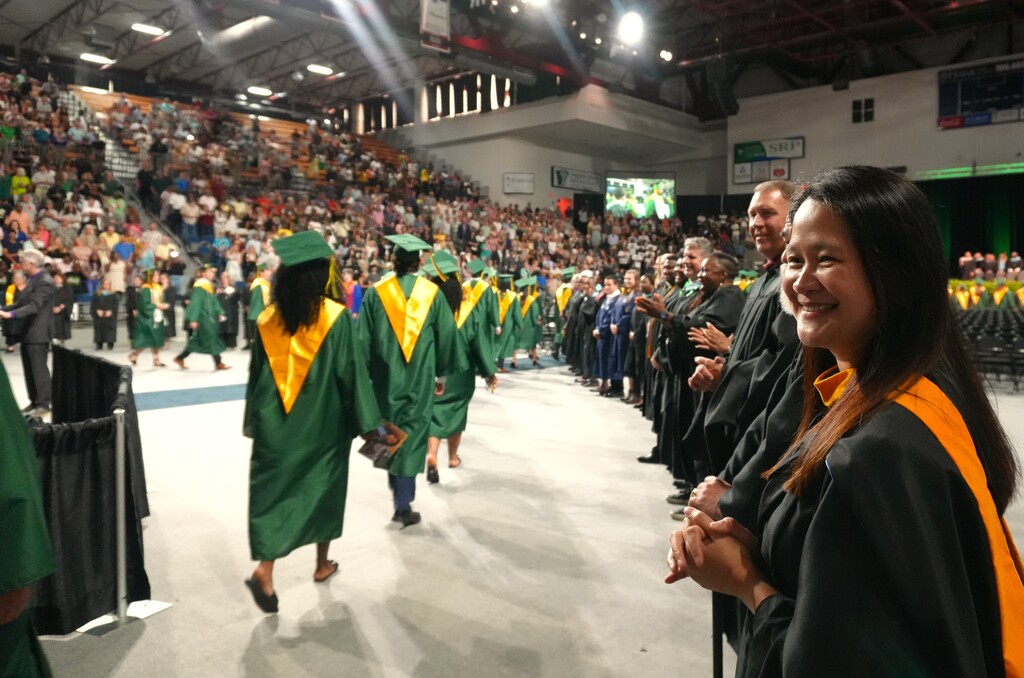 Aiken High teachers watch graduates process in.