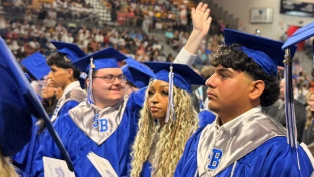 SBHS Graduate waving to their family during graduation.