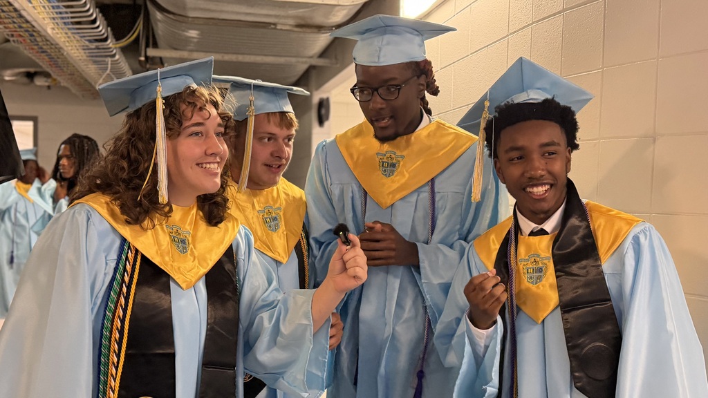 Students being interviewed before graduation while wearing the graduation caps and gowns.