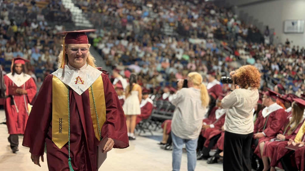 SAHS graduate walking with their diploma.