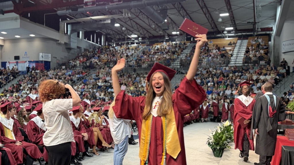 SAHS graduate walking with their diploma.