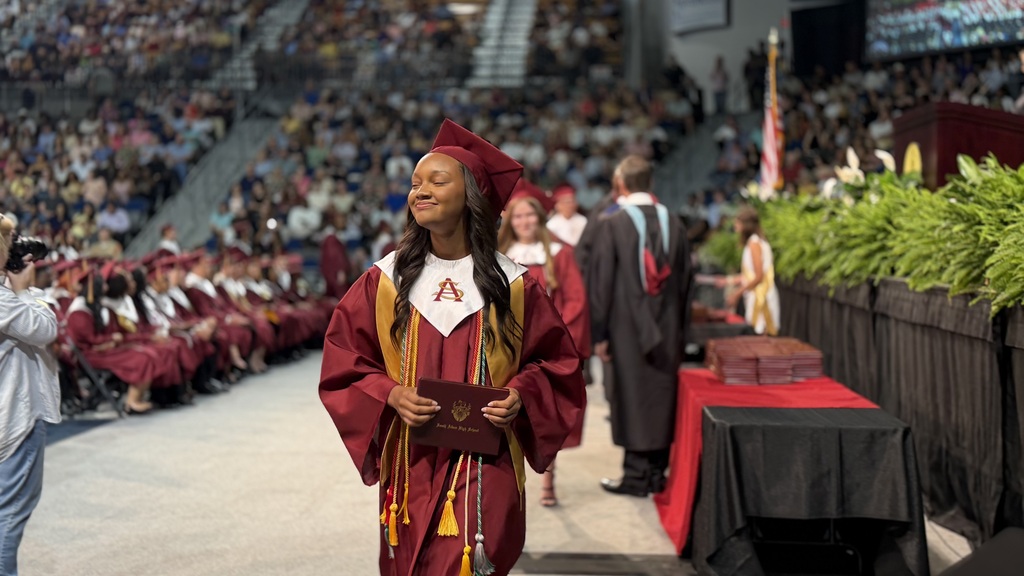 SAHS graduate walking with their diploma.