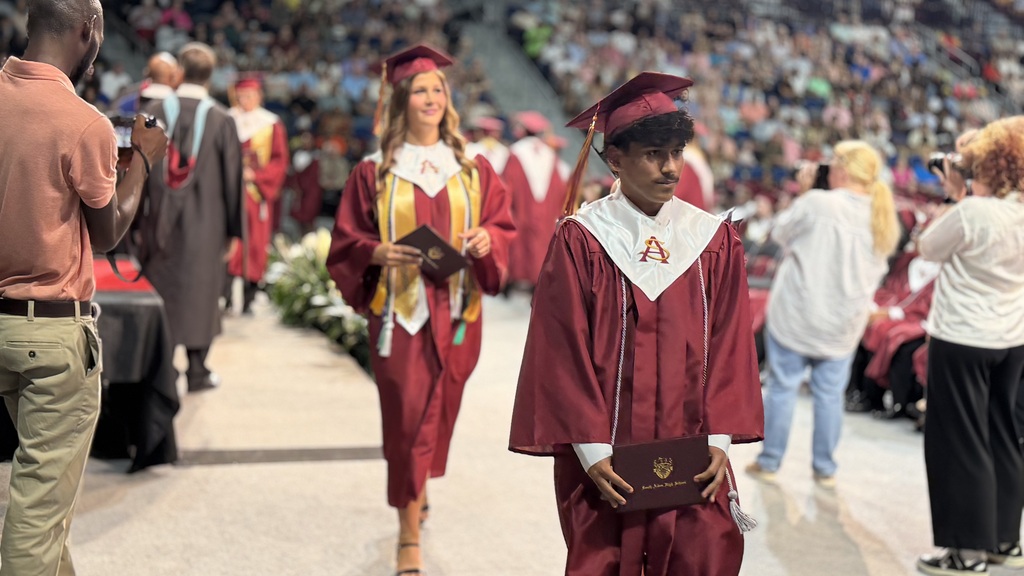 SAHS graduate walking with their diploma.