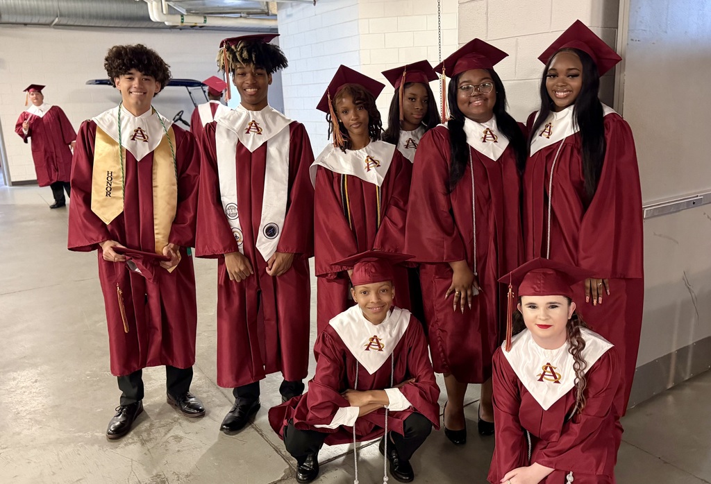 Graduates posing for a photo in their gowns prior to graduation.