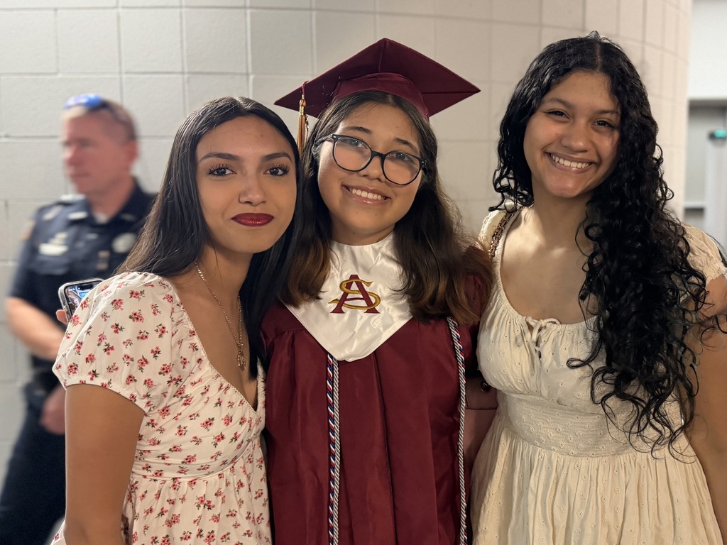 Graduates posing for a photo in their gowns prior to graduation.