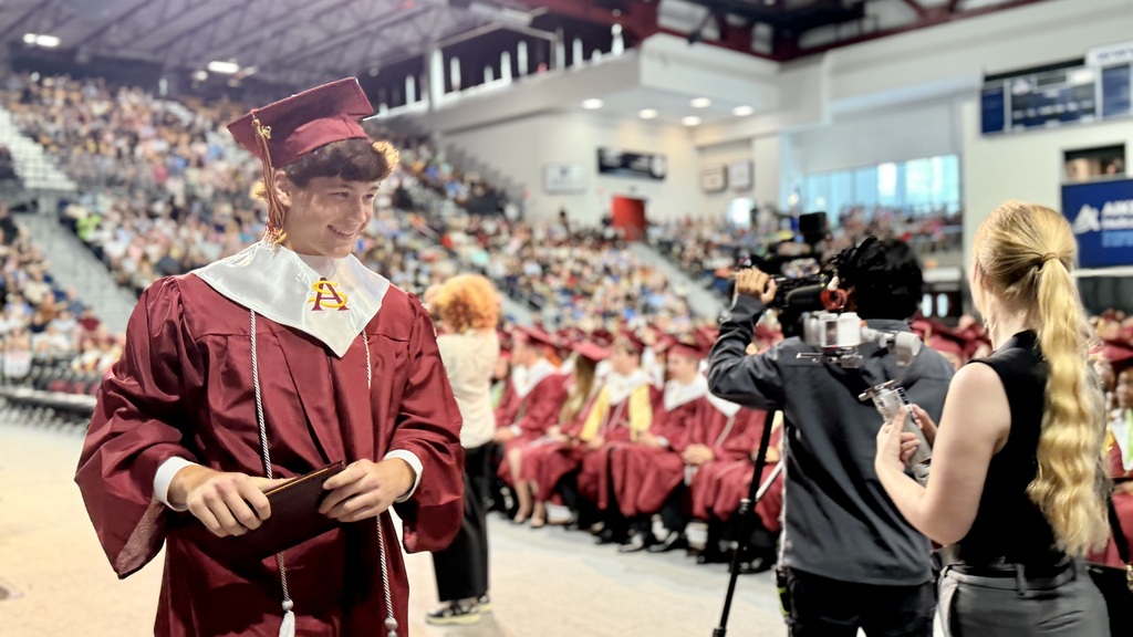 SAHS graduate walking with their diploma.
