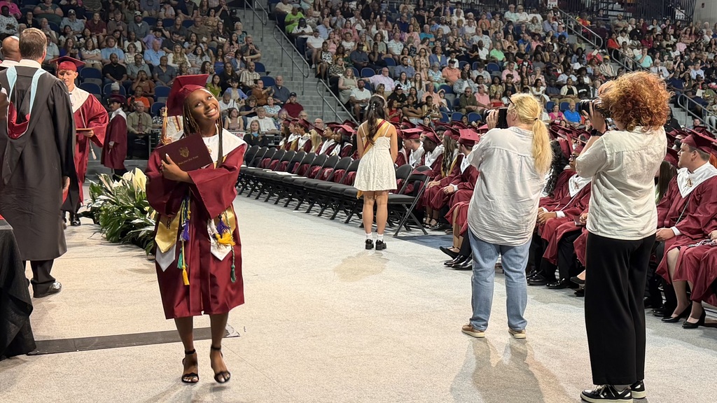 SAHS graduate walking with their diploma.