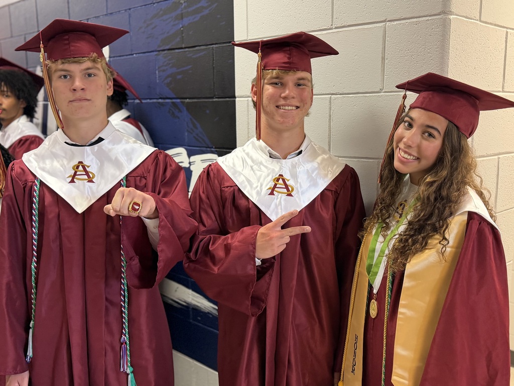 Graduates posing for a photo in their gowns prior to graduation.