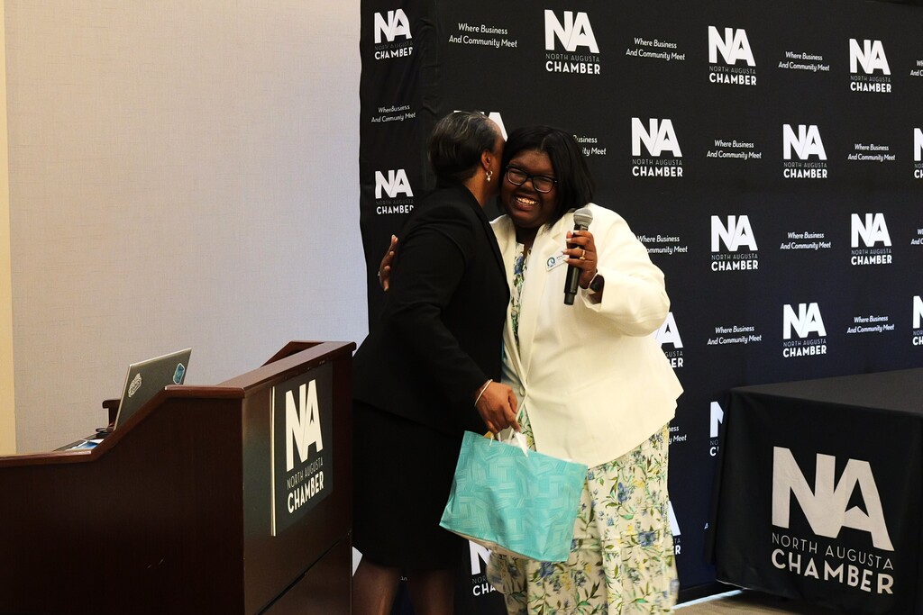 Terra Carroll hugging a graduate who presented her with a gift.