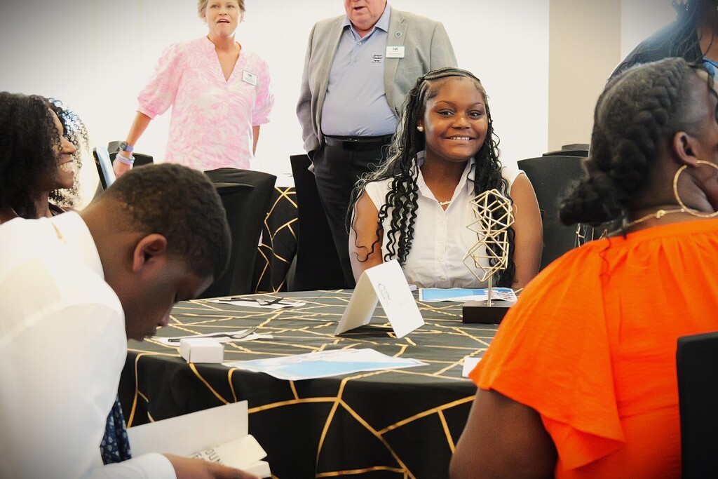 Junior Leadership graduate smiling at table.