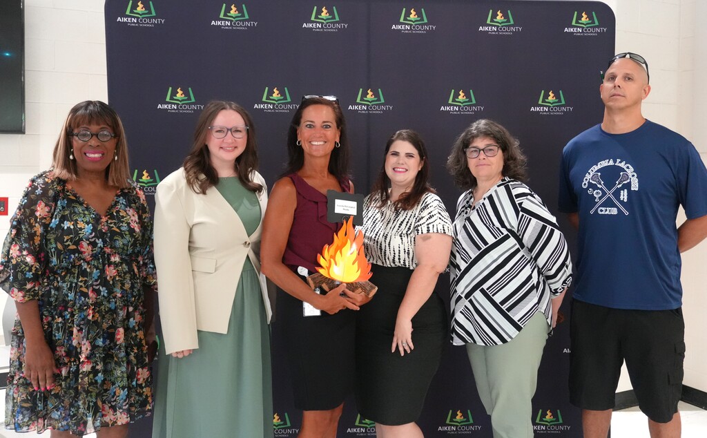 New teachers pose for a photo with their school prinicipal.