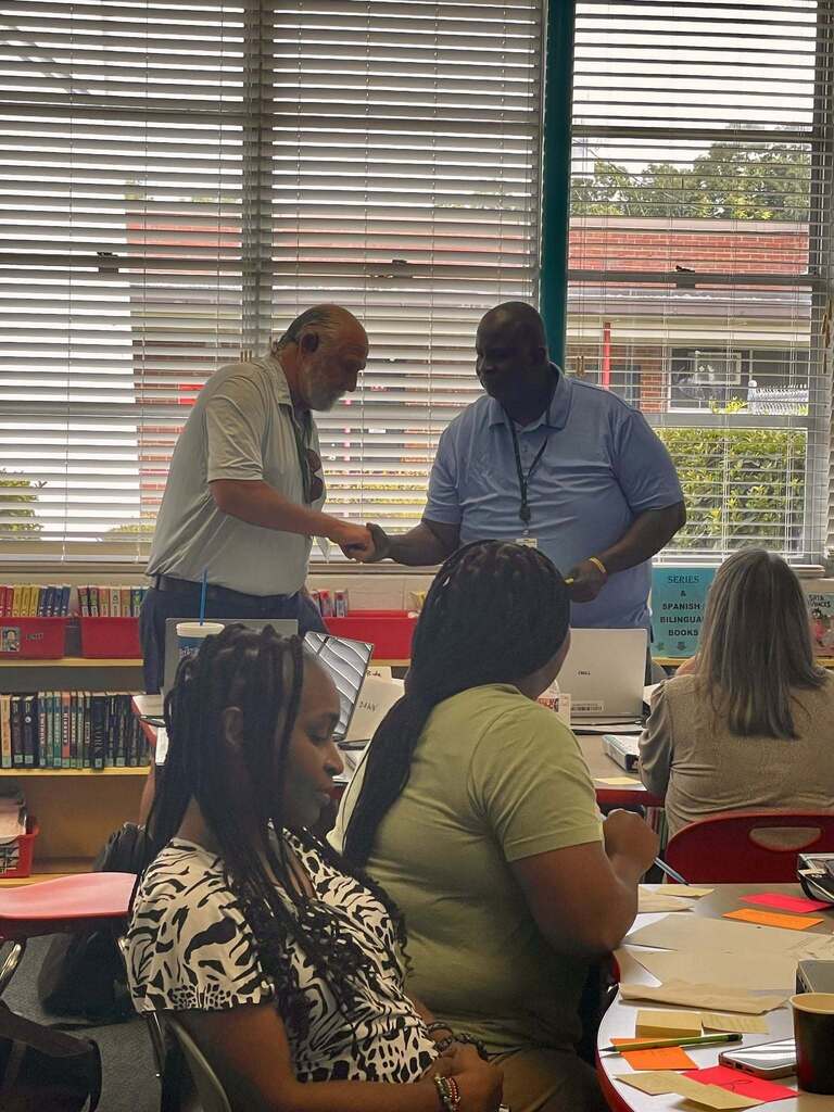 Social Studies teachers shaking hands.