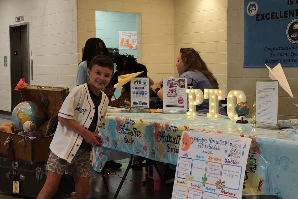 A Belvedere student smiles in front of a PTO table. 