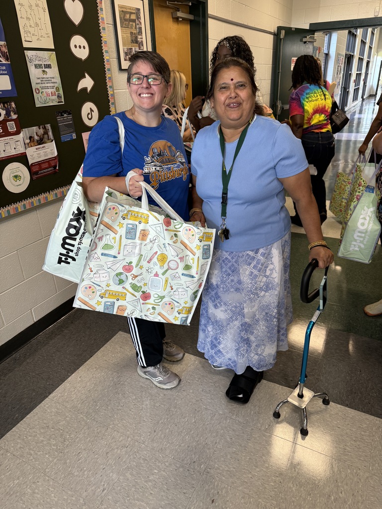 two people smiling and holding bags 