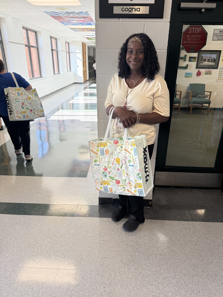 one person smiling and holding a bag 
