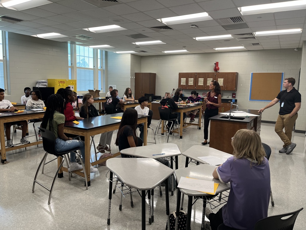 Principal speaking to 8th graders in a classroom.