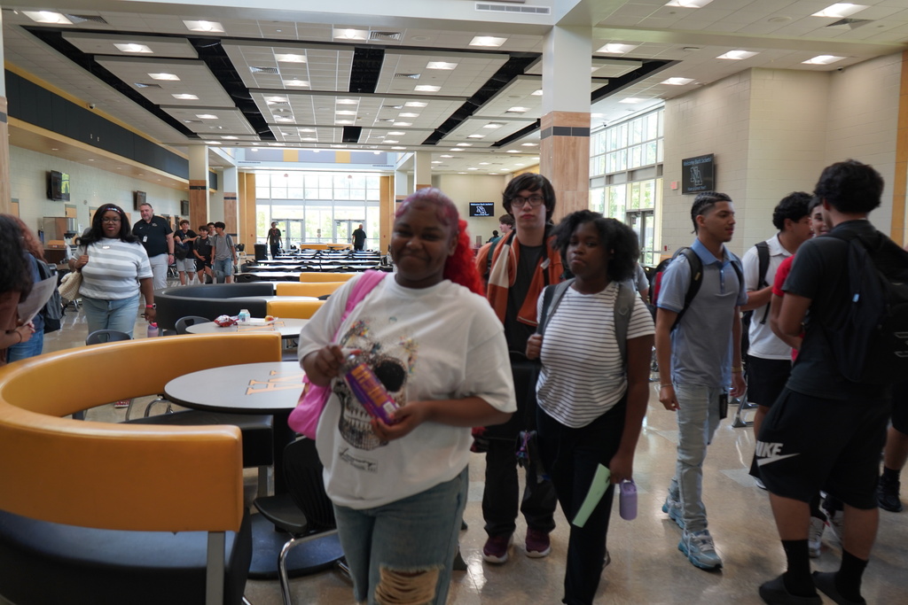 "Student Smiling for Camera with students behind her."