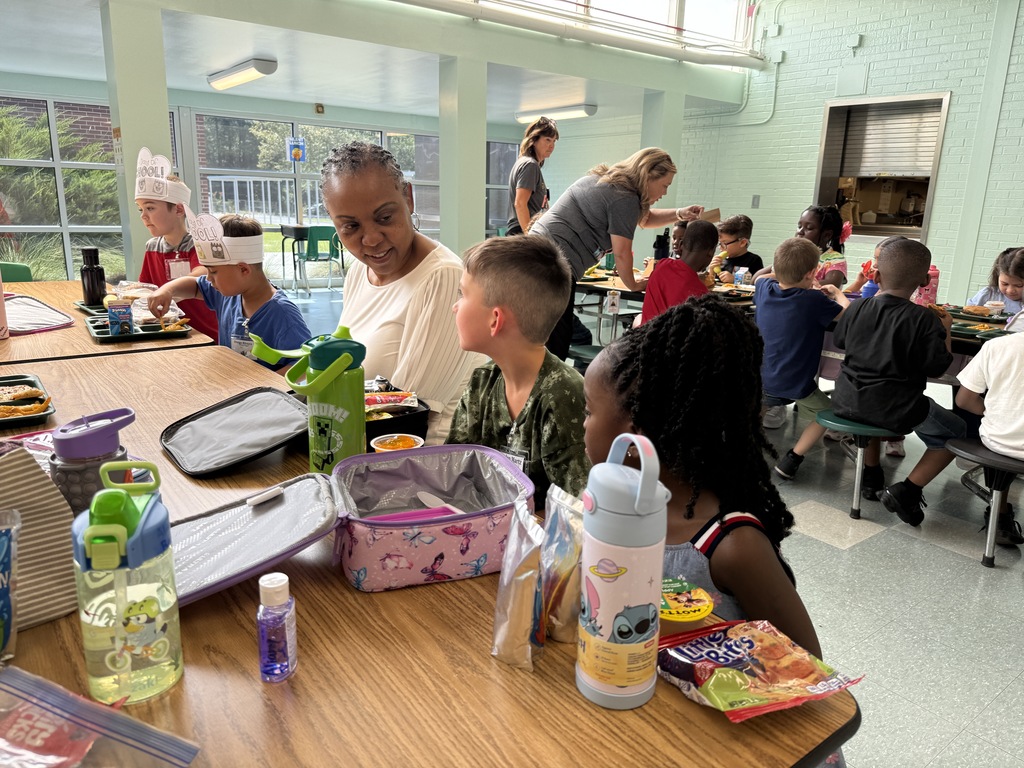 Dr. Phyllis Gamble sits with Elementary students at lunch.