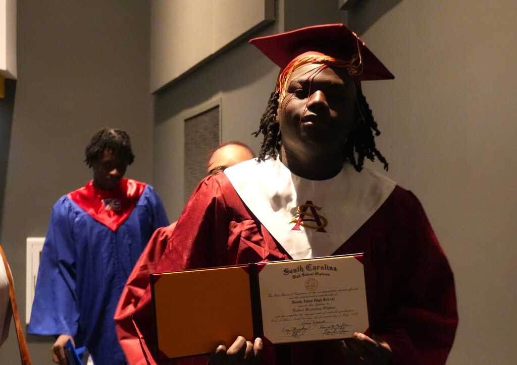 A summer graduate showcases his diploma.