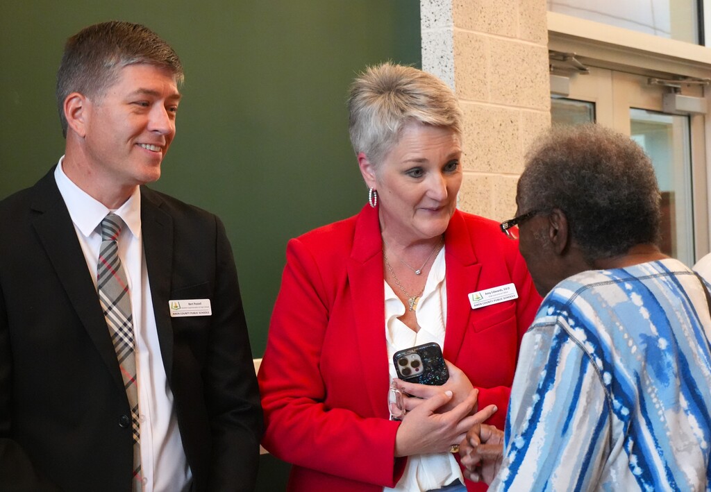 District leadership speaks with a family member during summer graduation.