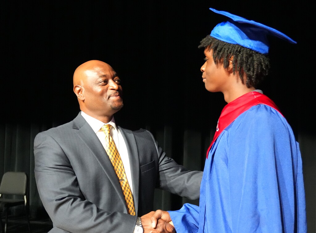 Dr. Corey Murphy shakes hands with a summer graduate.