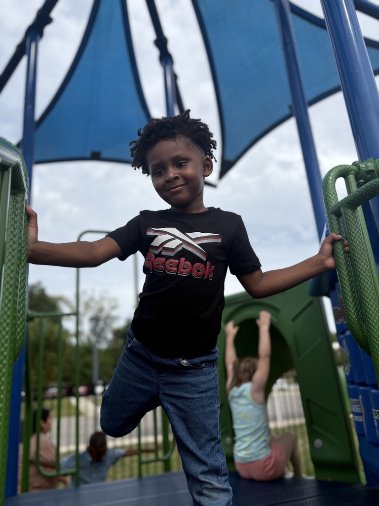 Image of a young student on playground equipment
