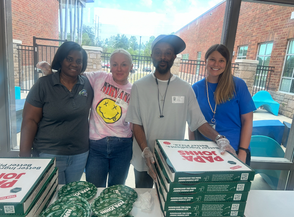 Highland Springs staff and volunteers pose together with pizza boxes