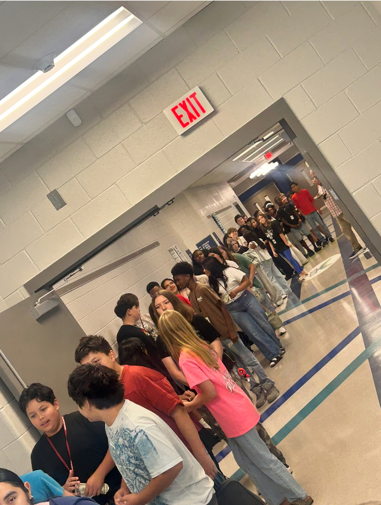 Long line of students in hallway, waiting for pizza