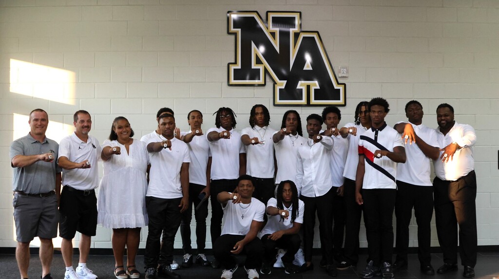Coaches and players showing off rings. 