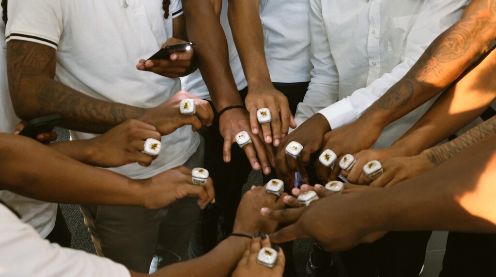 Hands in center circle showing off rings. 