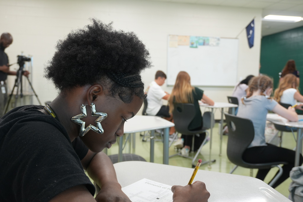 Student completing assignment in classroom.