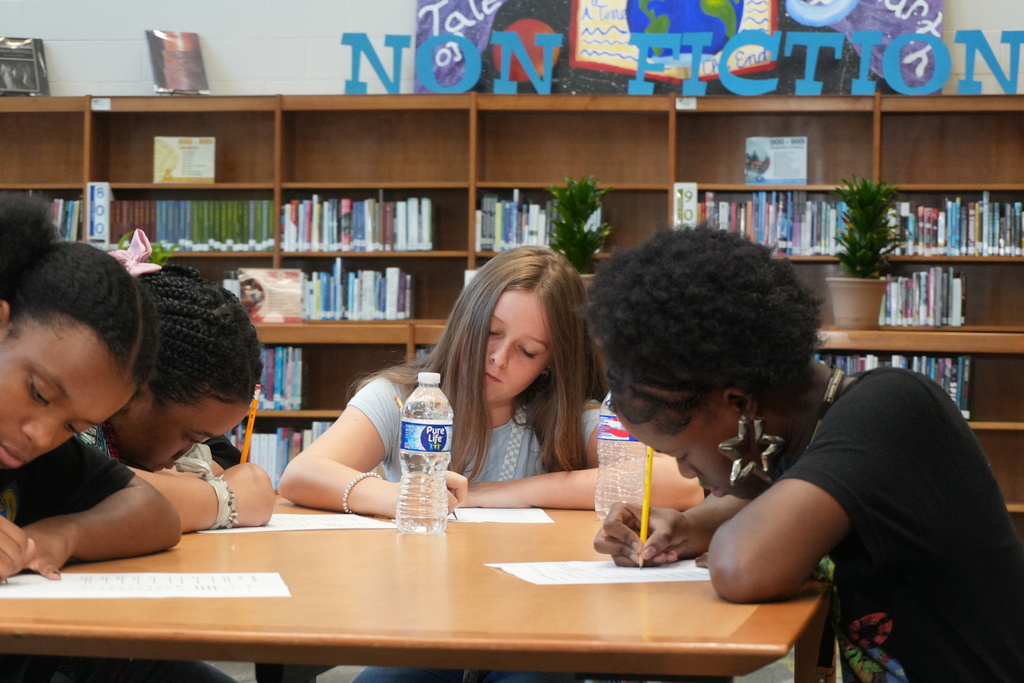 Students completing a written assignment in library.
