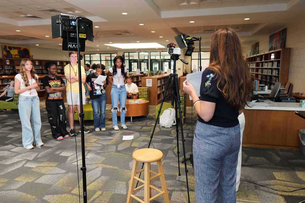 Five students in front of camera and lights.