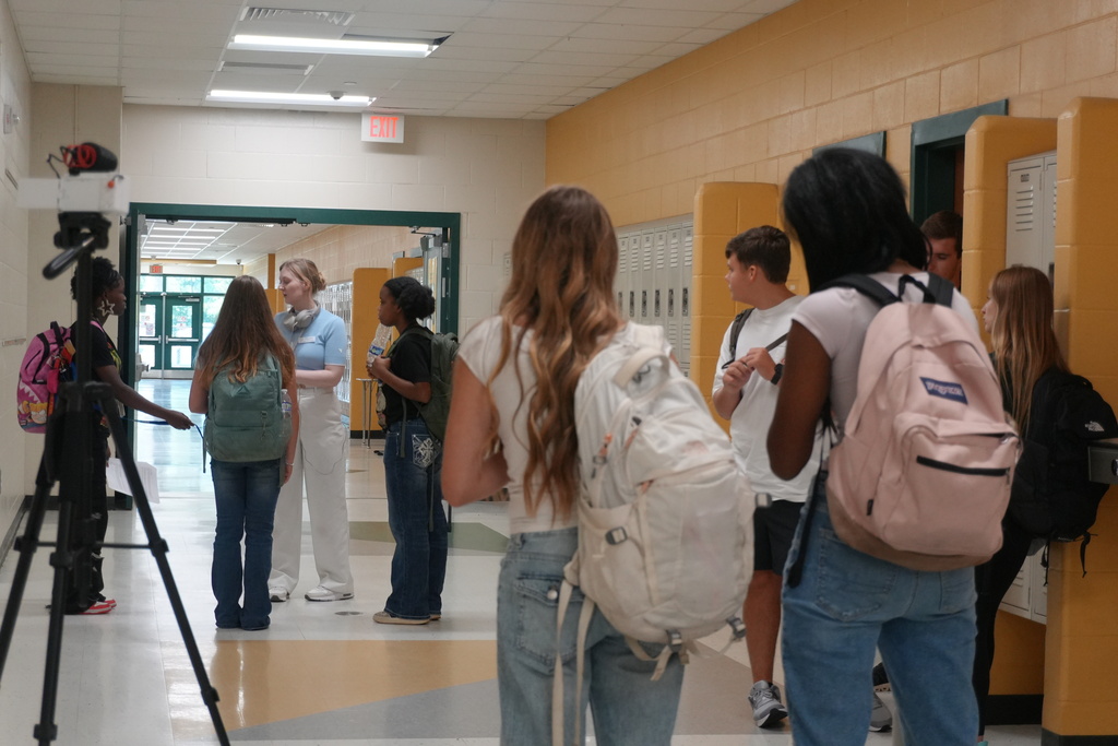 Students listening to directions in hallway.