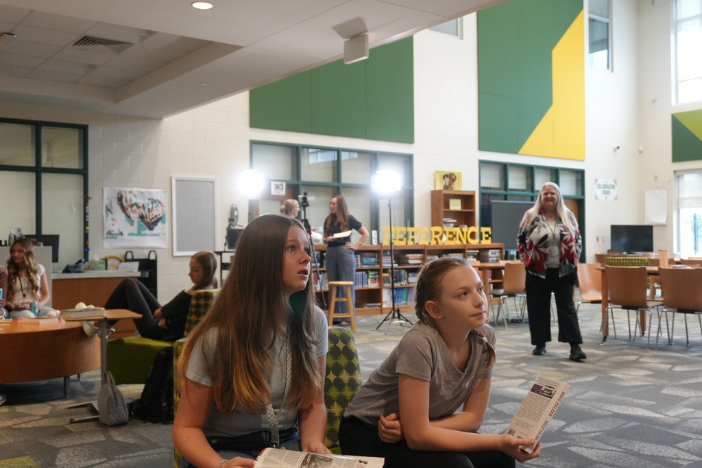 Students listening to diretions in library.