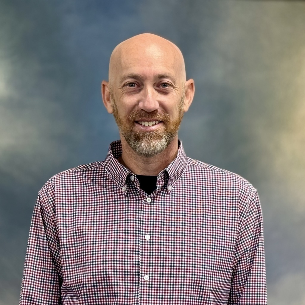 Smiling man in a checkered shirt. 