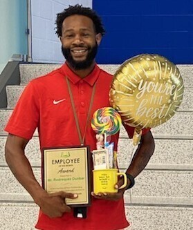 Mr. Dunbar holding an employee of the month award.