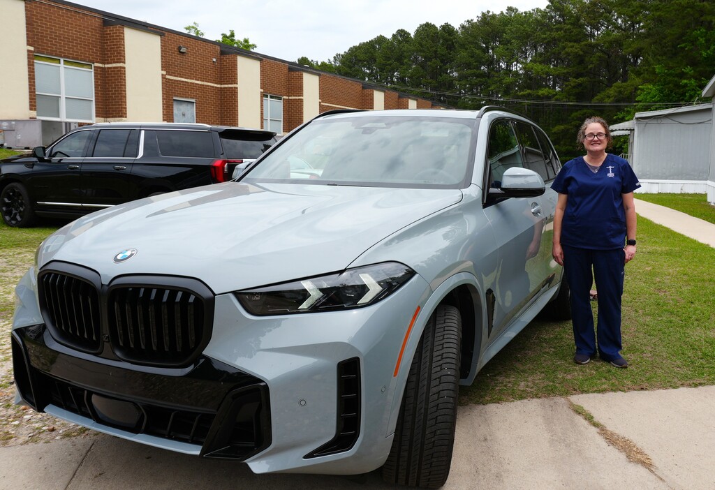 Dr. Palladino  poses by the BMW she was awarded for a year for winning South Carolina Teacher of the Year.