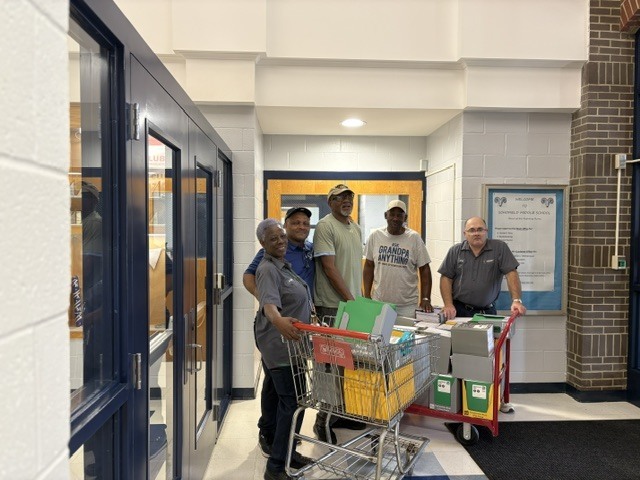 A picture of a group standing around a shopping cart