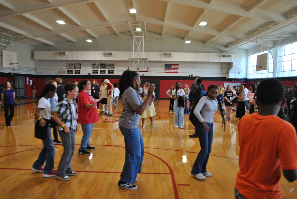 Students and a teacher line dancing.