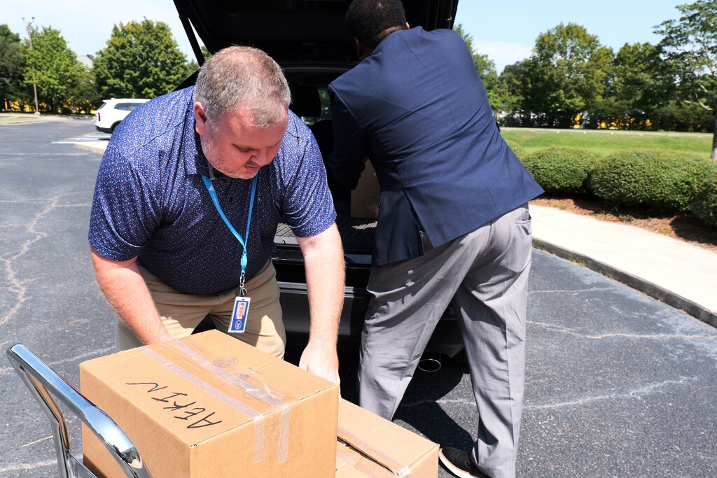Two men loading boxes of donated items onto a cart. 