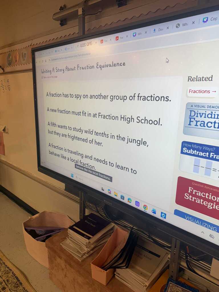 A classroom screen displays a lesson on fraction equivalence. Boxes of books are on a table in front of the screen.