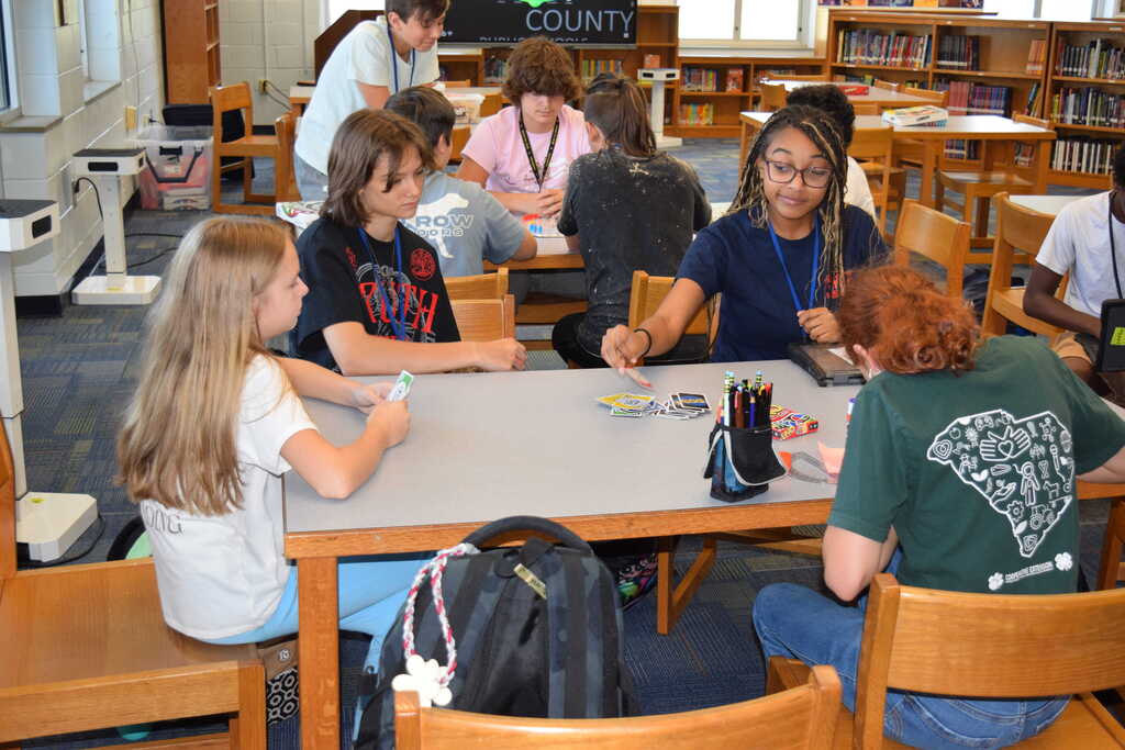 Students playing card game in library