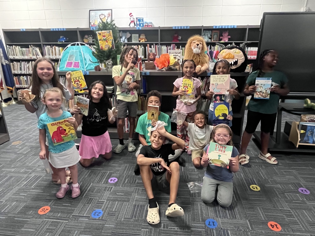 Group of students holding books and smiling at the camera